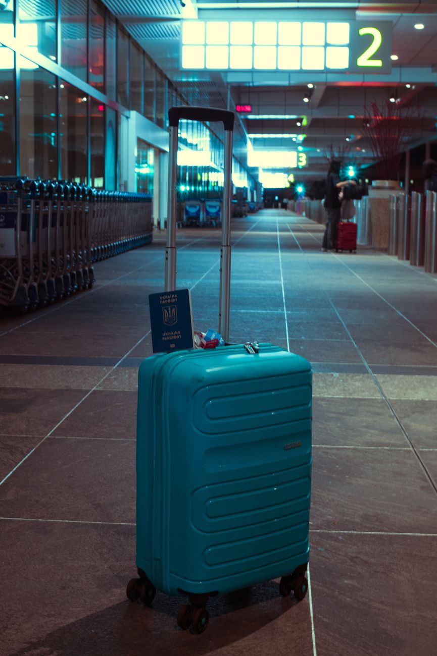blue suitcase in empty airport terminal