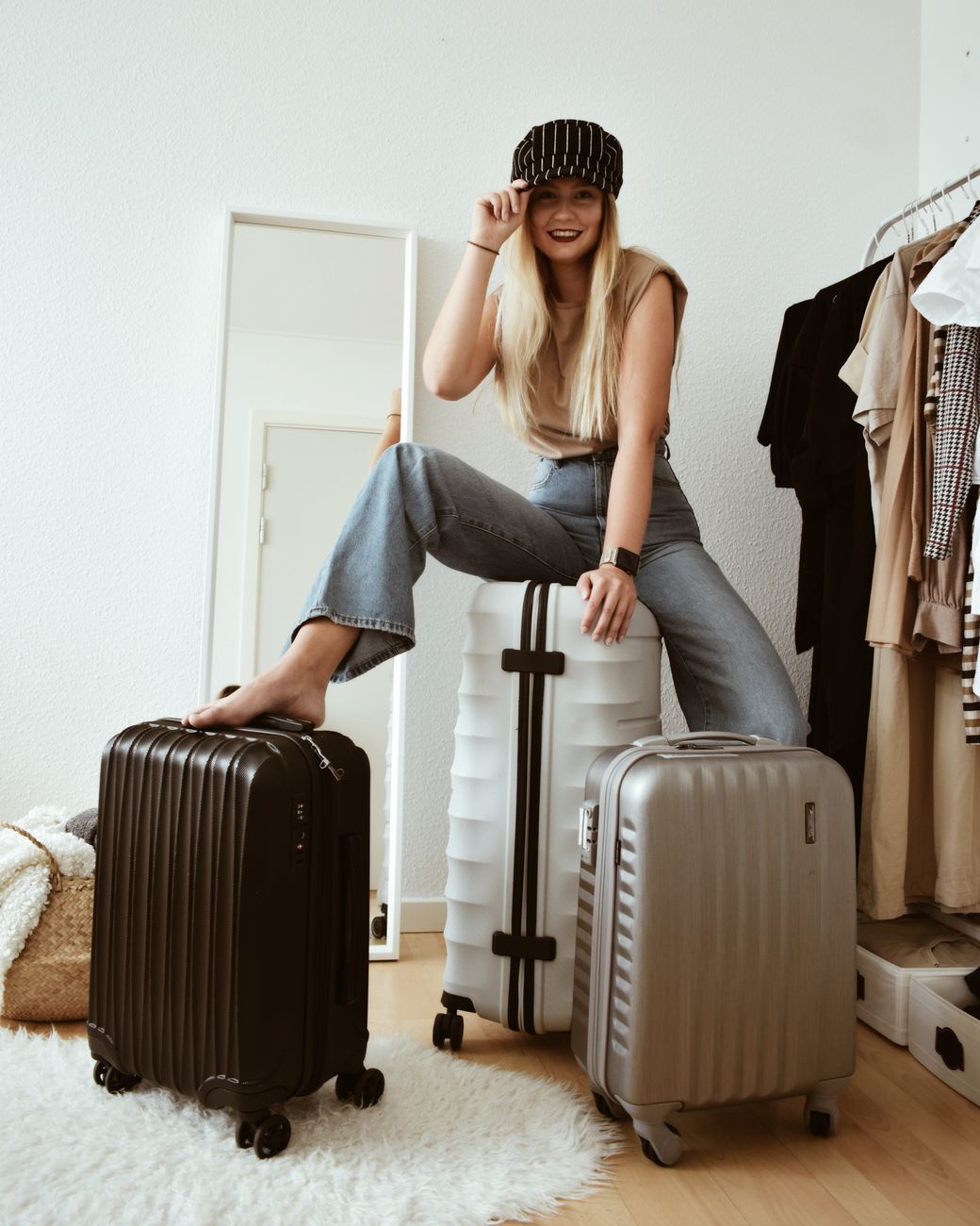 woman in jeans sitting on luggage